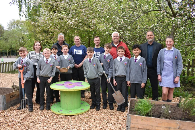 A photo showing Monkspath School's eco council with school sustainability lead Kelly Jarvis, Hill & Smith staff, Cllr Ken Hawkins, and headteacher Dan Wild in the new eco-garden
