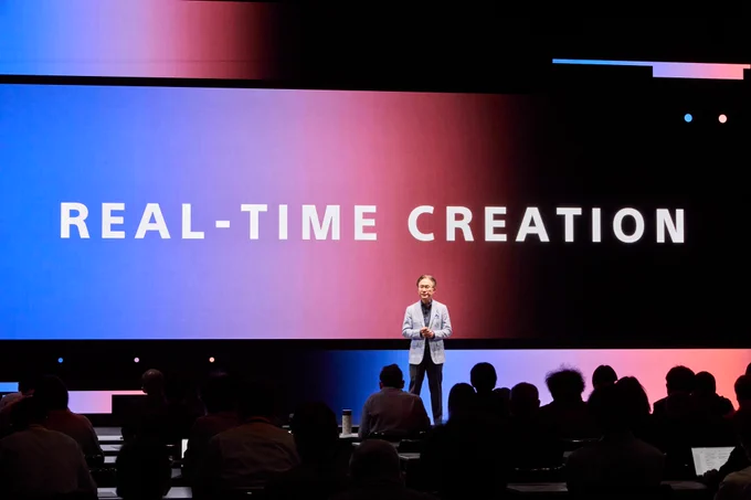 At the Sony Group’s Corporate Strategy Meeting 2024, Chairman and CEO Kenichiro Yoshida stands in front of a screen displaying "REAL-TIME CREATION" and talks about the direction of Sony’s management and real-time creation.