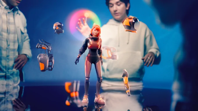 A red-haired, female virtual avatar stands on a round table with different wearable pieces of equipment floating around her. A man stands behind the avatar, operating the controls.