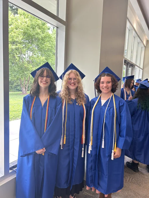 Three graduates smiling for a photo.