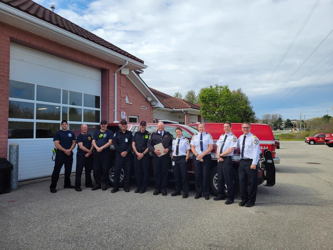 Photo of PC Gravill in front of a fire truck with Alpha platoon to acknowledge his 25 years of service with Waterloo Fire Rescue