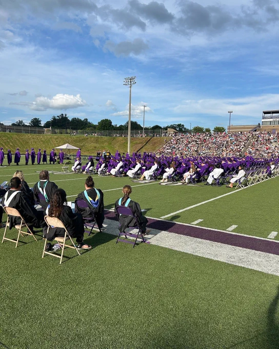 Graduates on the field with teachers.