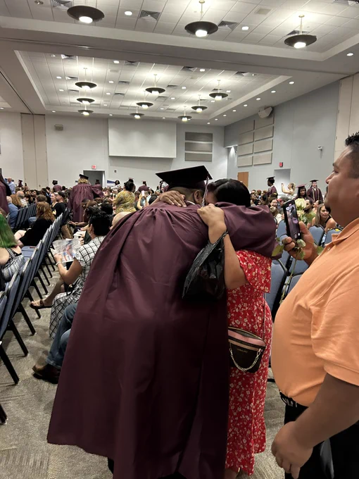 A graduate hugging his mom.