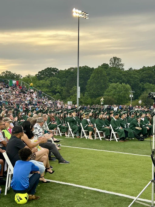 Graduates sitting in chairs facing the stage.