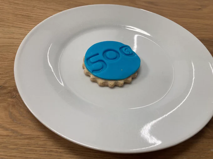 A biscuit with blue icing and an imprinted “500” and parkrun logo