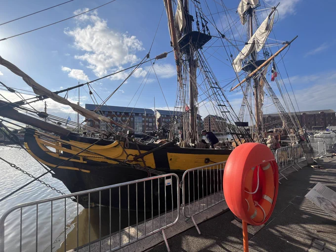 Large sailing ship on the dockside . Lifebuoy in the foreground.
