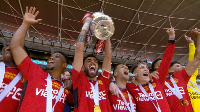 Bruno Fernandes lifts the FA Cup trophy at Wembley surrounded by his team-mates.
