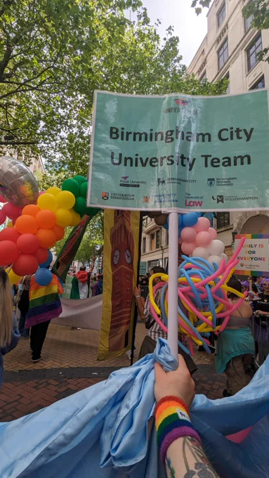 Photo of a hand holding a banner saying “Birmingham City University team”