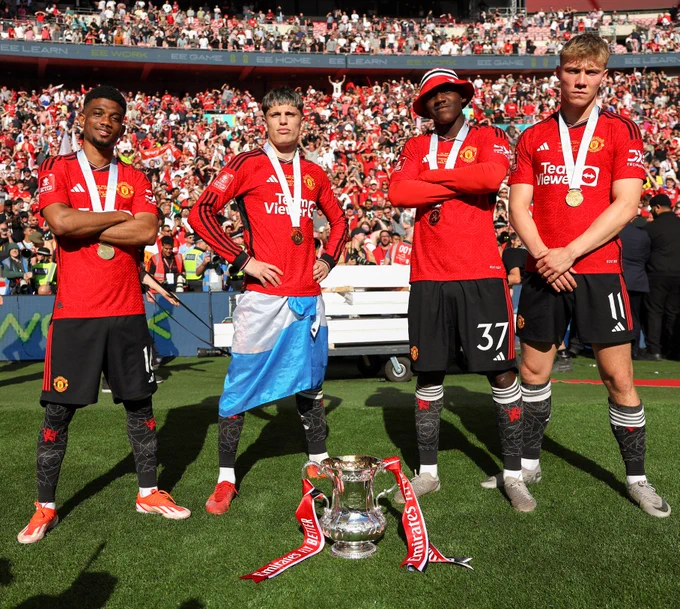Amad, Alejandro Garnacho, Kobbie Mainoo and Rasmus Hojlund pose with the FA Cup trophy in front of our fans at Wembley.