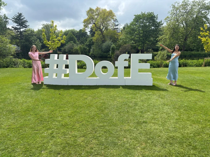 Photo of two young people next to a #DofE sign.