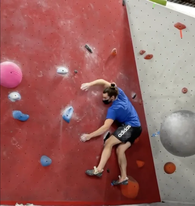 A photo of Ben on a rock climbing wall.