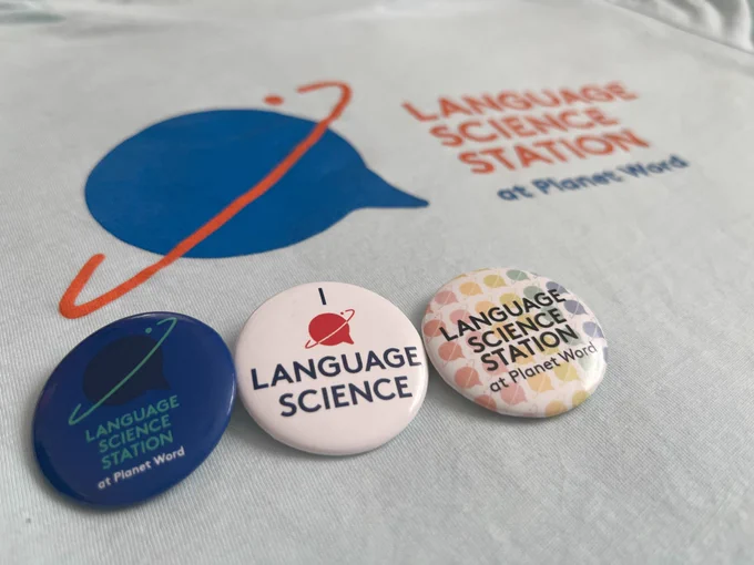Three LSS pins displayed on a t-shirt printed with the LSS logo.