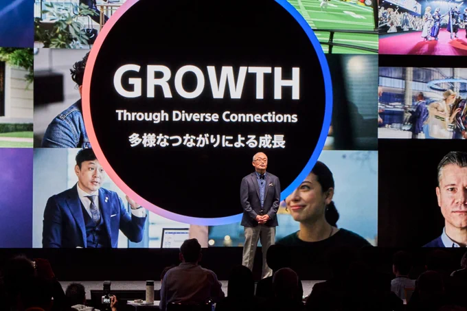 Sony President, COO and CFO Hiroki Totoki is pictured on stage giving a presentation to participants. Behind him, the word "GROWTH" is displayed in all caps with "Through Diverse Connections" underneath.