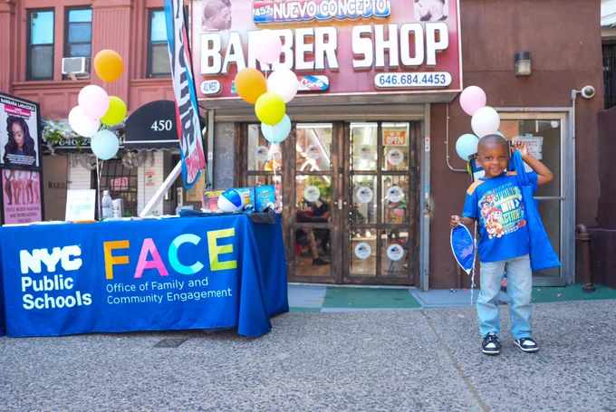 Student poses in front of NYC Reading Hub Ribbon Cutting at Nuevo Concepto Barber Shop on Harlem.