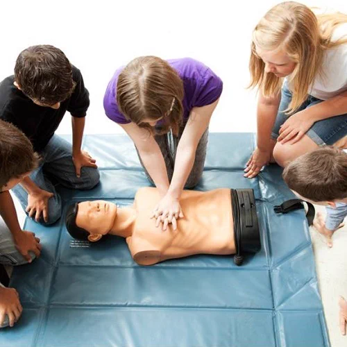 Group of people practising CPR on a mannequin