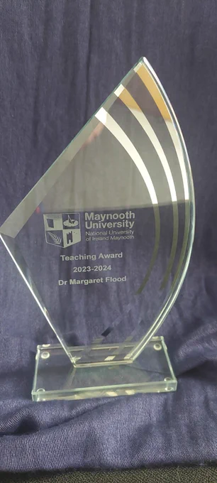 Sail shaped trophy. Engraved on it is the Maynooth University logo and the text "Teaching Awards 2023-2024. Dr Margaret Flood"