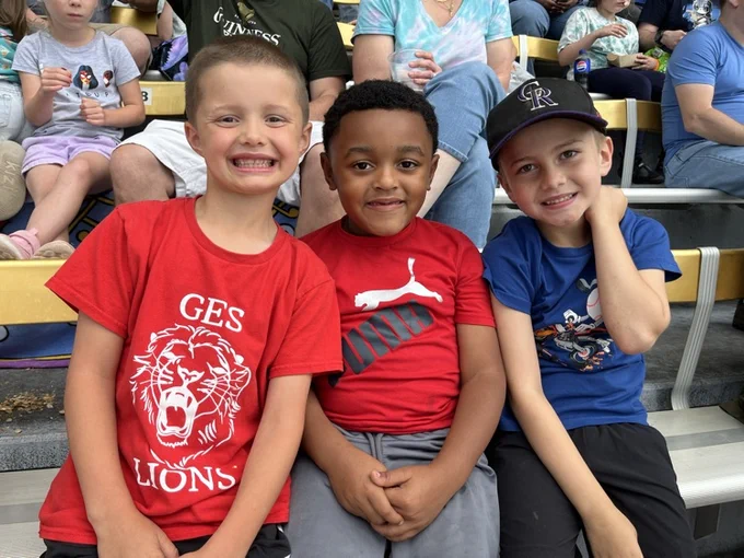 Three boys at a baseball game 
