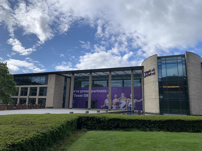 Royal Bank of Scotland building in Gogarburn in foreground. Green grass in front of building. Partly cloudy sky. Bright and beautiful day. Team GB advert on building.