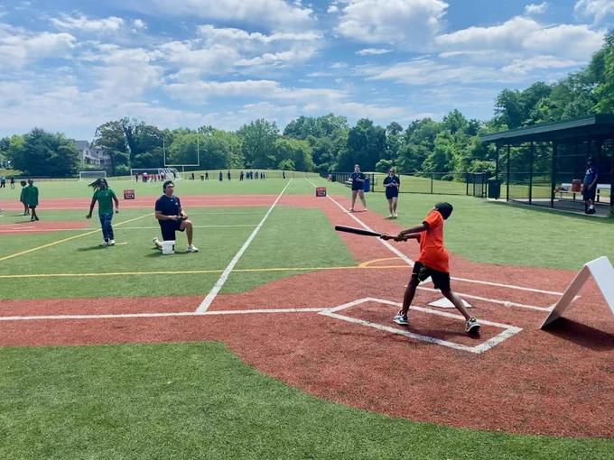 A youth ballplayer swings at a pitch.