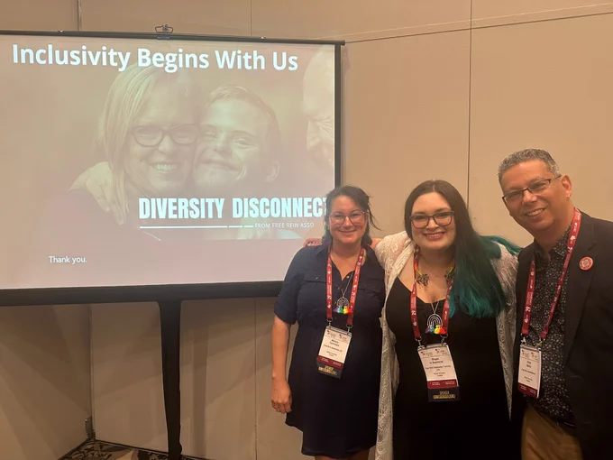 Photo of three people in front of a session slide.