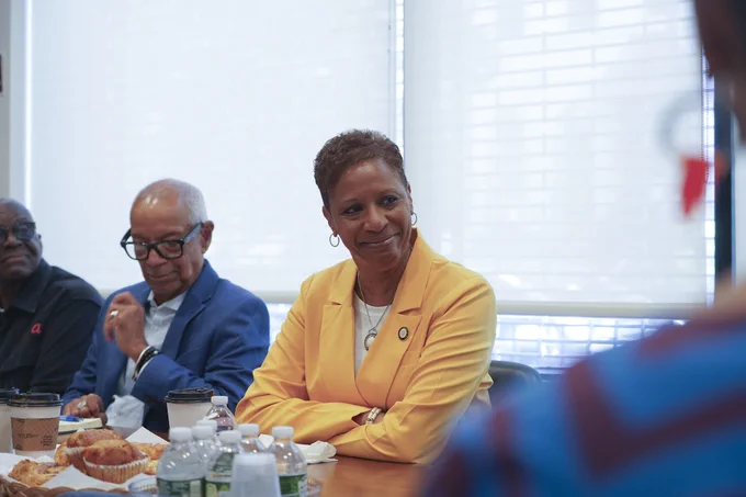 Speaker Adams siting at a table smiling 