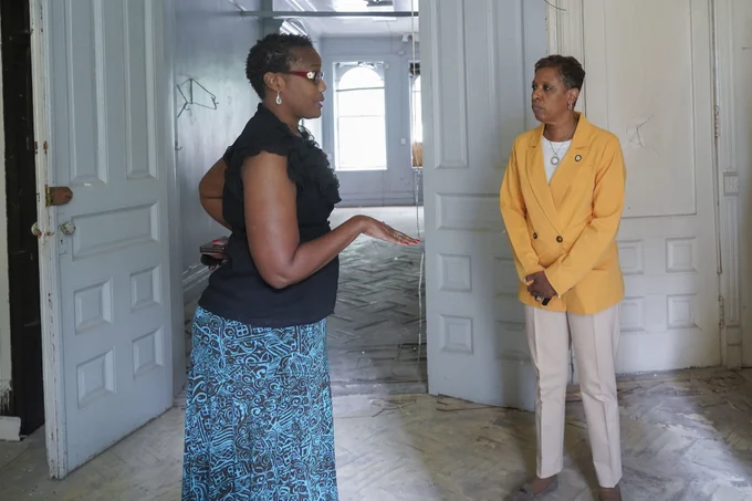 Speaker Adams being led on a tour of a building by another woman