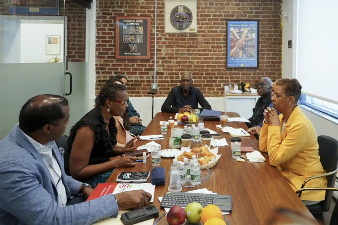 Speaker Adams siting at a table with others having a discussion 