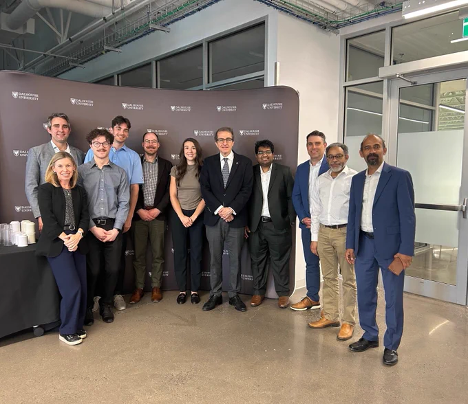 IMAGE: Eleven people standing in from of a Dalhousie University Wall smiling at the camera. From left to right: Dr. Janie Wilson, Dr Locke Davenport Huyer, Brendan Wheeler, Adam Dorrance, Marc Andre Simard, Emalie Hayes, Alejandro Adem, Hasan Shahrier, Dr Graham Gagnon, Dr Claver Diallo, Dr Ahsan Habib
