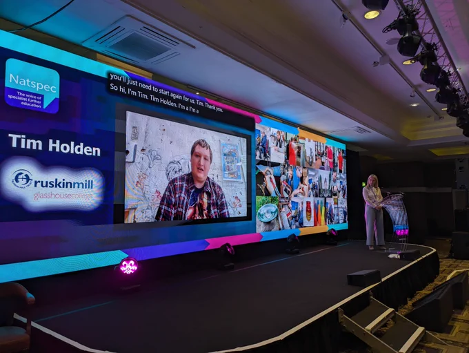 Tim, a young white man in a plaid shirt, visible on the Natspec screen as he dials into the conference.