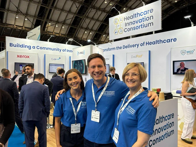 Healthcare Innovation Consortium team smiling in front of stand