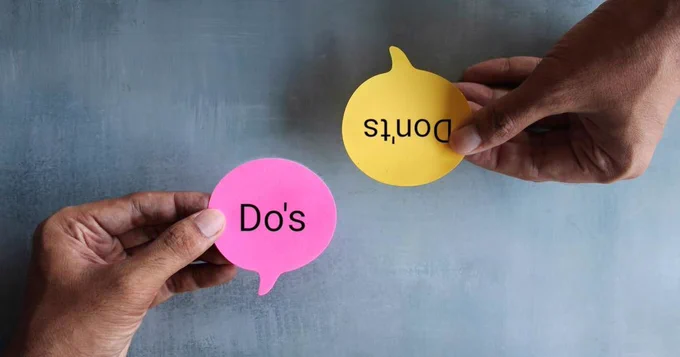 Two hands. One is ride side up holding a pink note that says “Do’s” and the other is holding a yellow note upside down that says “dont’s” 