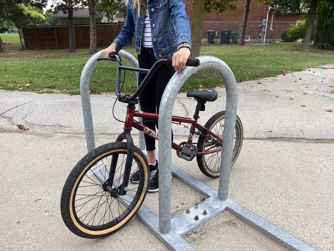 Student with their bike at a bike rack.