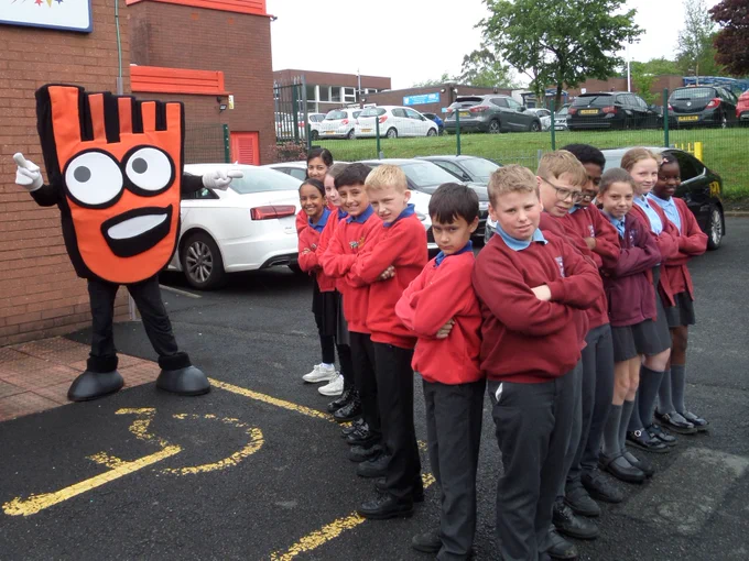 Two rival groups of schoolchildren act tough for the camera, encouraged by Living Streets' mascot, Strider.