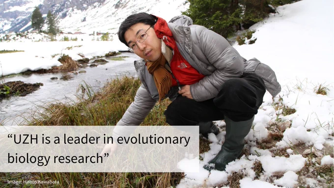A man wearing a red scarf and grey jacket kneels in a snowy mountain landscape by a small stream. Text: "UZH is a leader in evolutionary biology research"