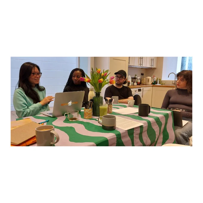 Four people in discussion around a kitchen table.