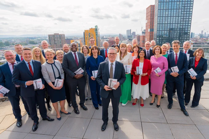 Keir Starmer pictured with his team holding the Labour manifesto. Title reads: Change.
