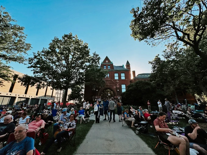People gather outside Architecture Hall for Jazz in June as the sun sets behind it