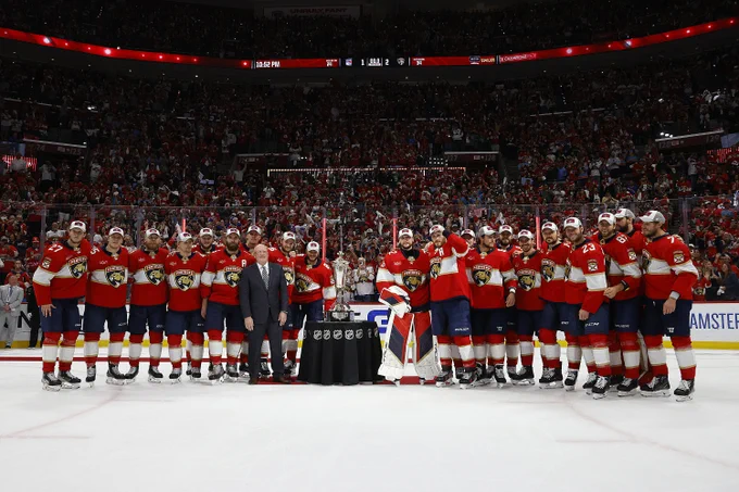 The entire Florida Panthers team on the ice in Panthers uniforms posing for a photo with the Prince of Wales Trophy after winning the Eastern Conference Final.
