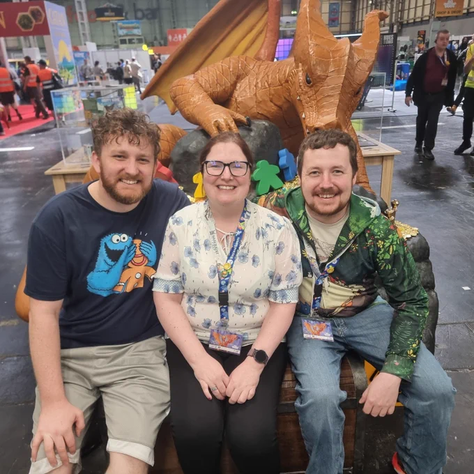 The staff of Decking Awesome Games in front of the UK games expo dragon