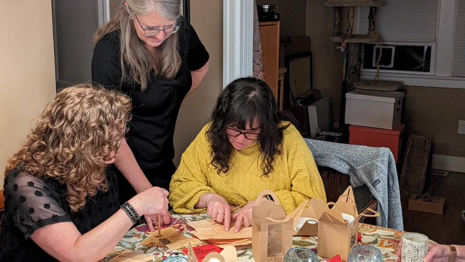 Three women looking at papers in front of them.