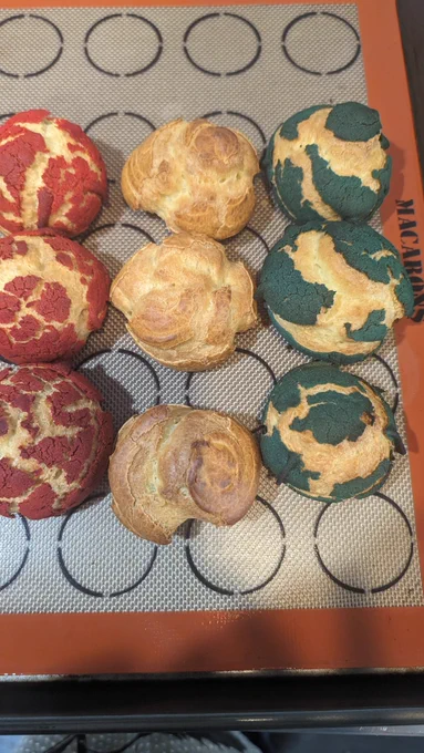 9 undecorated cream puffs on a baking sheet