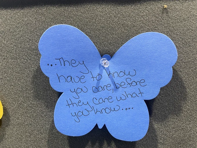 Blue paper butterfly with text that reads: They have to know you care, before they care what you know