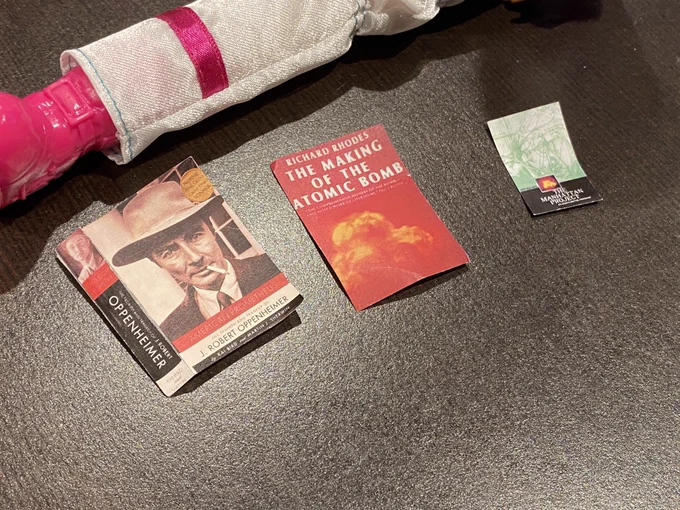Photo close-up of 3 miniature books (American Prometheus, The Making of the Atomic Bomb, and The Manhattan Project).