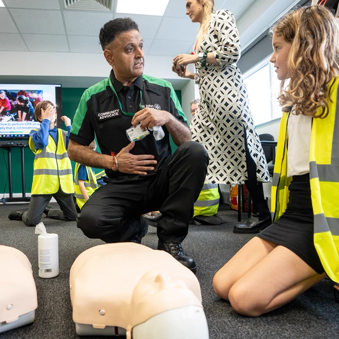 A St John Community Advocate teaches children first aid.