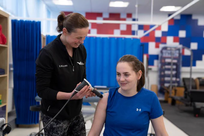 An athlete receiving physio from a physiotherapist 