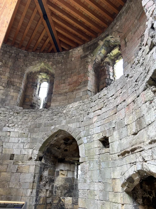 A curved section of the interior of the tower. There are windows near the top and a larger alcove on the lower section.