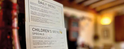 A blurry background, with a picture of a Daily Menu and Children's Menu sign.