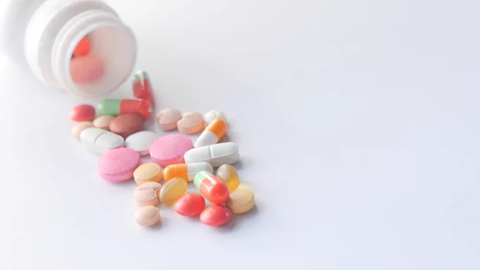 Close up of Colorful Pills Spilling on White Background