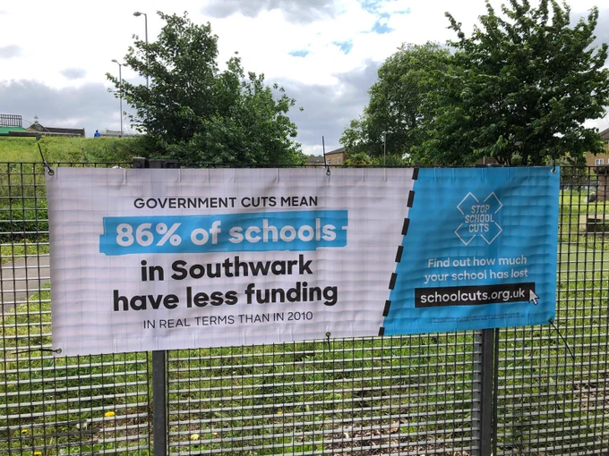 Image of school cuts banner hanging on a fence in Southwark. Banner said "Government cuts mean 86% of school in Southwark have less funding in real terms than in 2010".