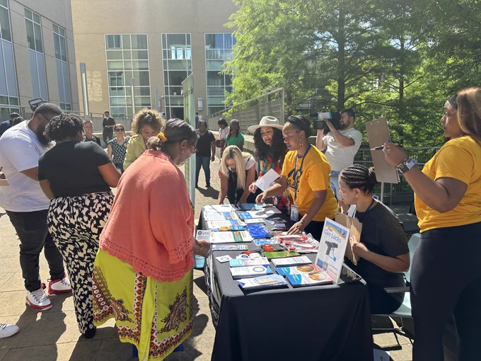 A crowd of people and workers at a gun lock giveaway providing gun locks and resources